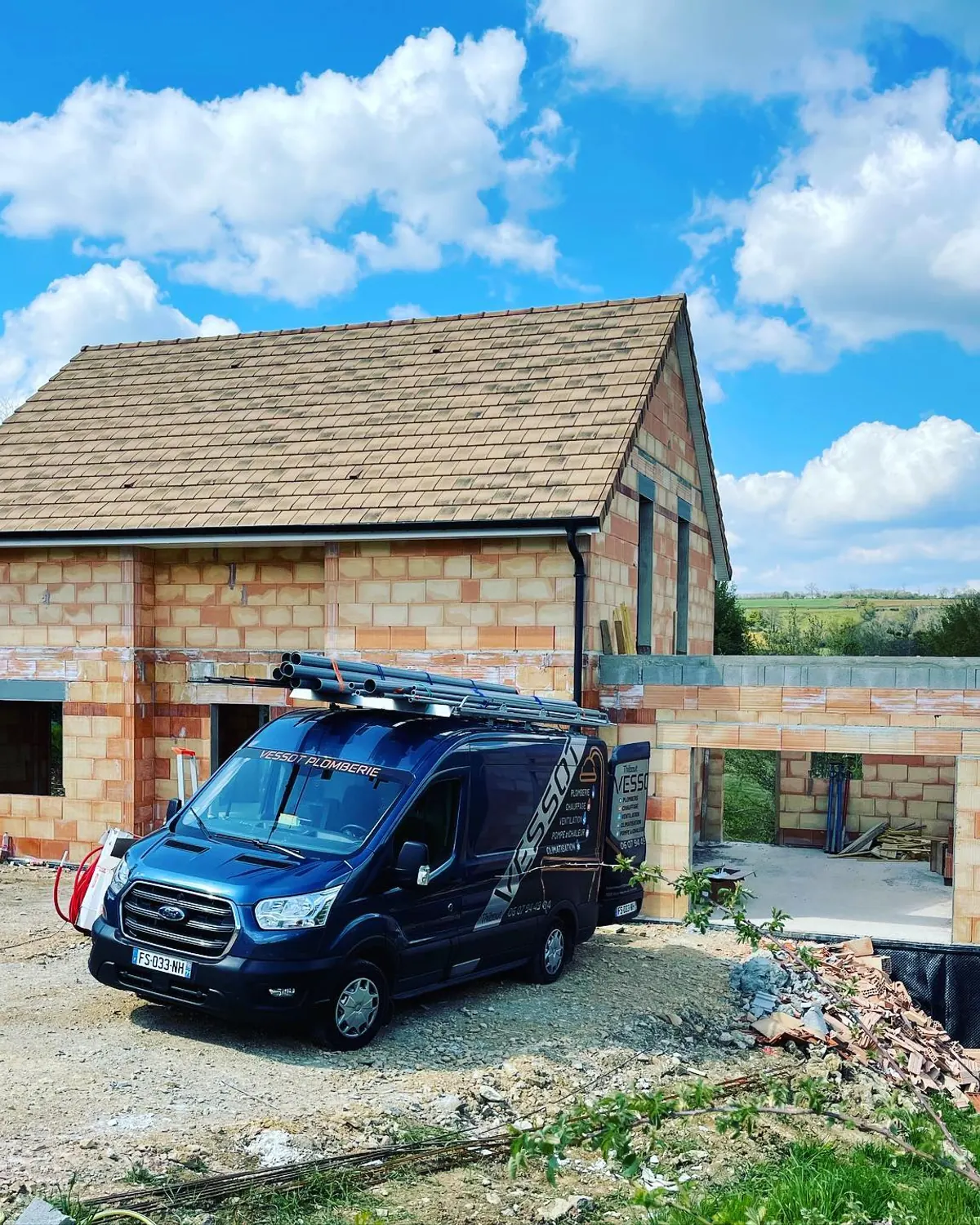 Fourgon VESSOT PLOMBERIE devant une maison en pierre en construction dans le Mâconnais