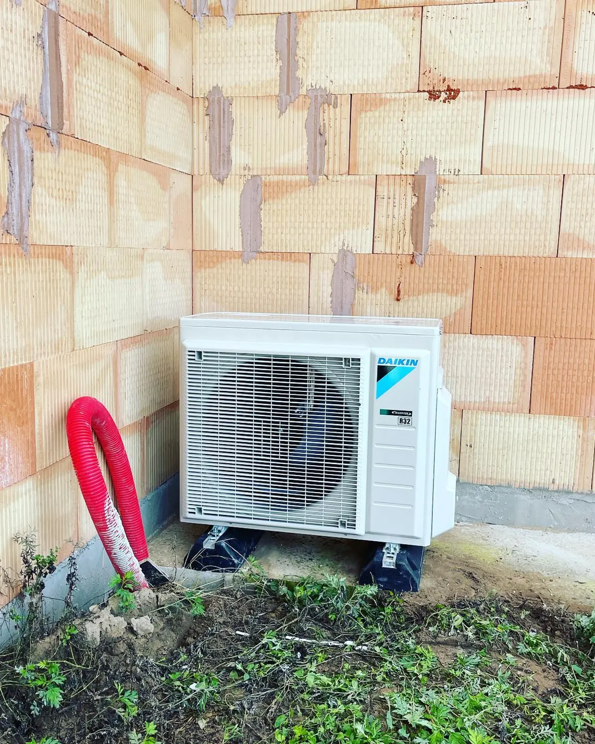Unité extérieure de pompe à chaleur installée sur une maison neuve