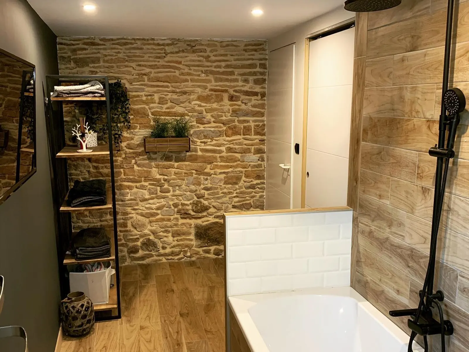 Salle de bain avec baignoire et mur de pierre dans une extension du Mâconnais