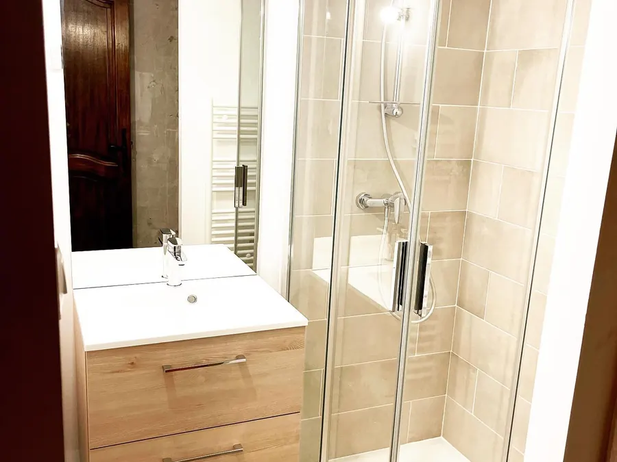 Salle de bain avec douche accessible et meuble vasque